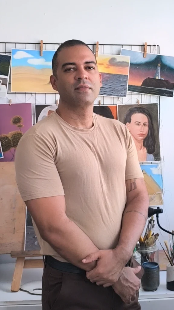 O A artista Andrei Silva, em frente às suas pinturas do Andrei Silva Atelier